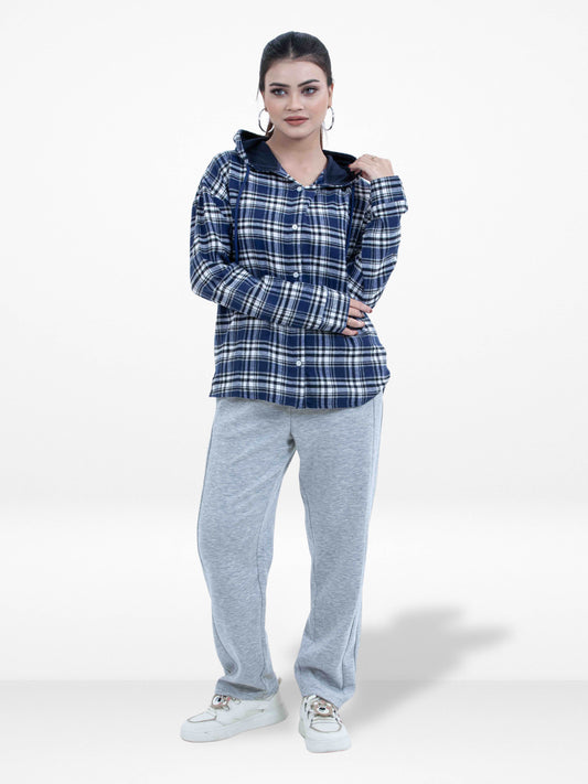Woman wearing a blue plaid shirt and gray pants on a white background