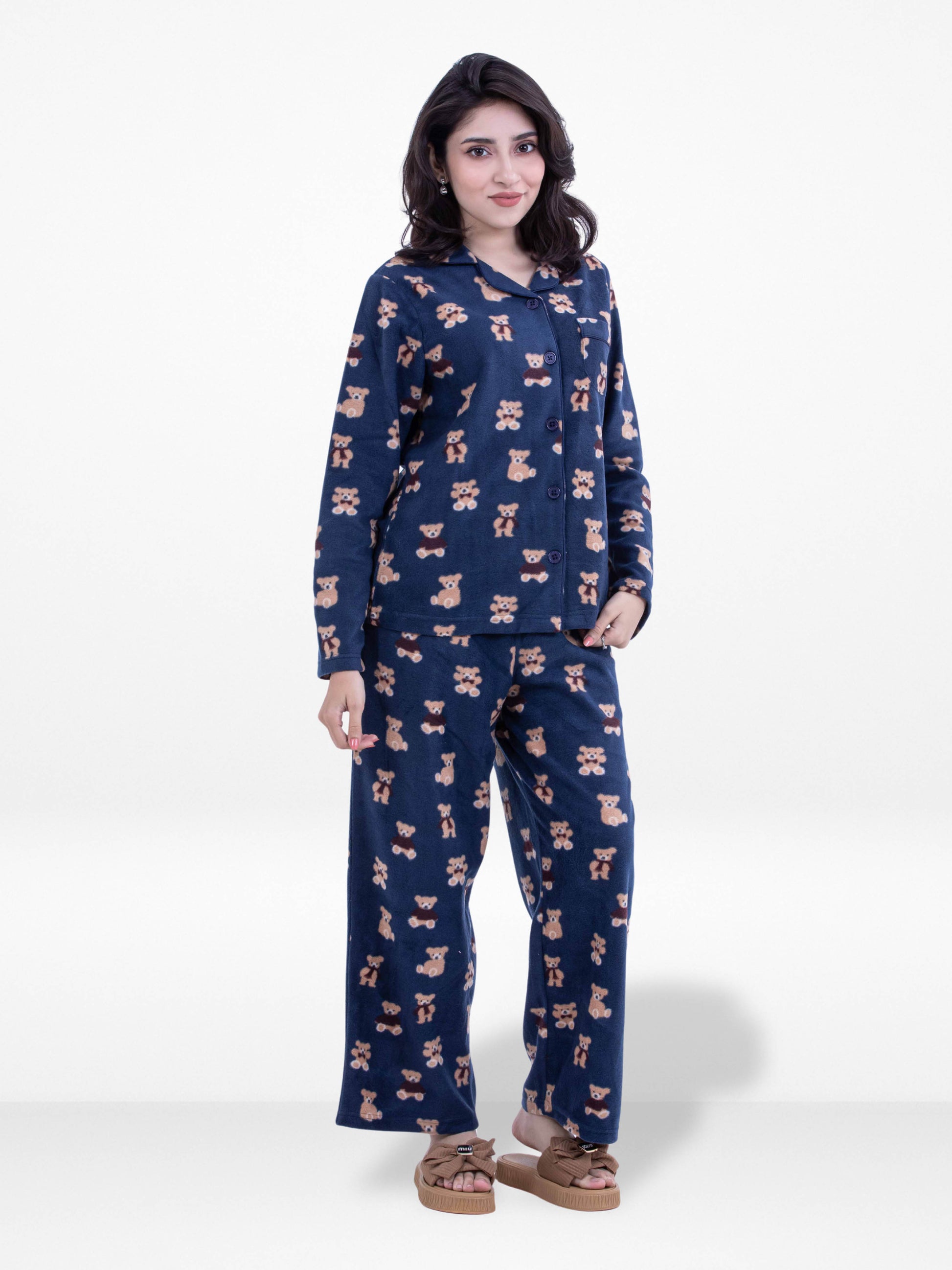 Woman wearing a navy blue pajama set with a pattern on a white background