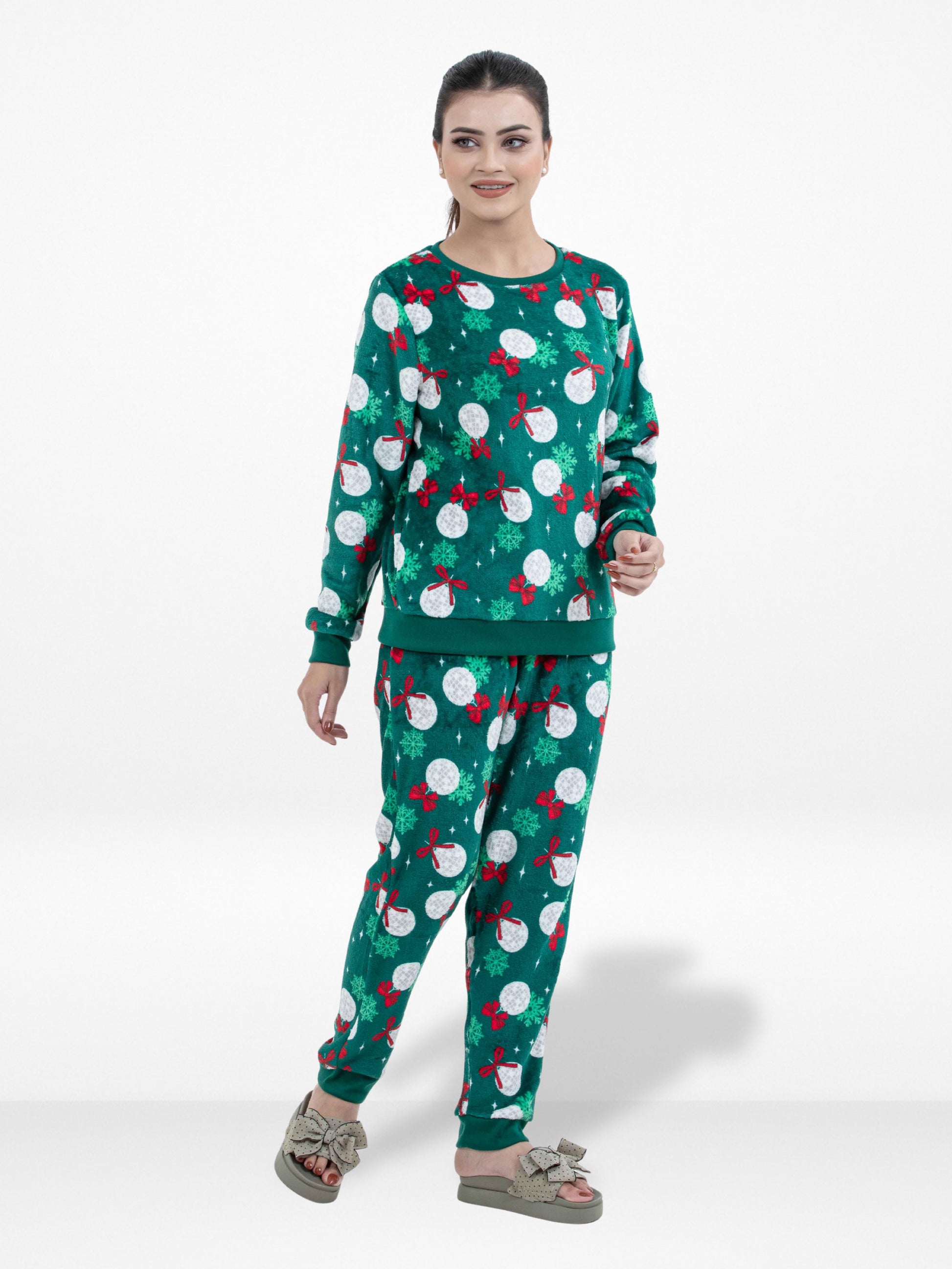 Woman wearing a green pajama set with red and white patterns on a white background