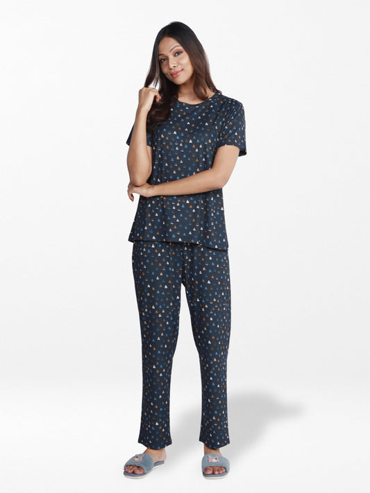 Woman wearing a navy blue pajama set with a subtle pattern on a white background