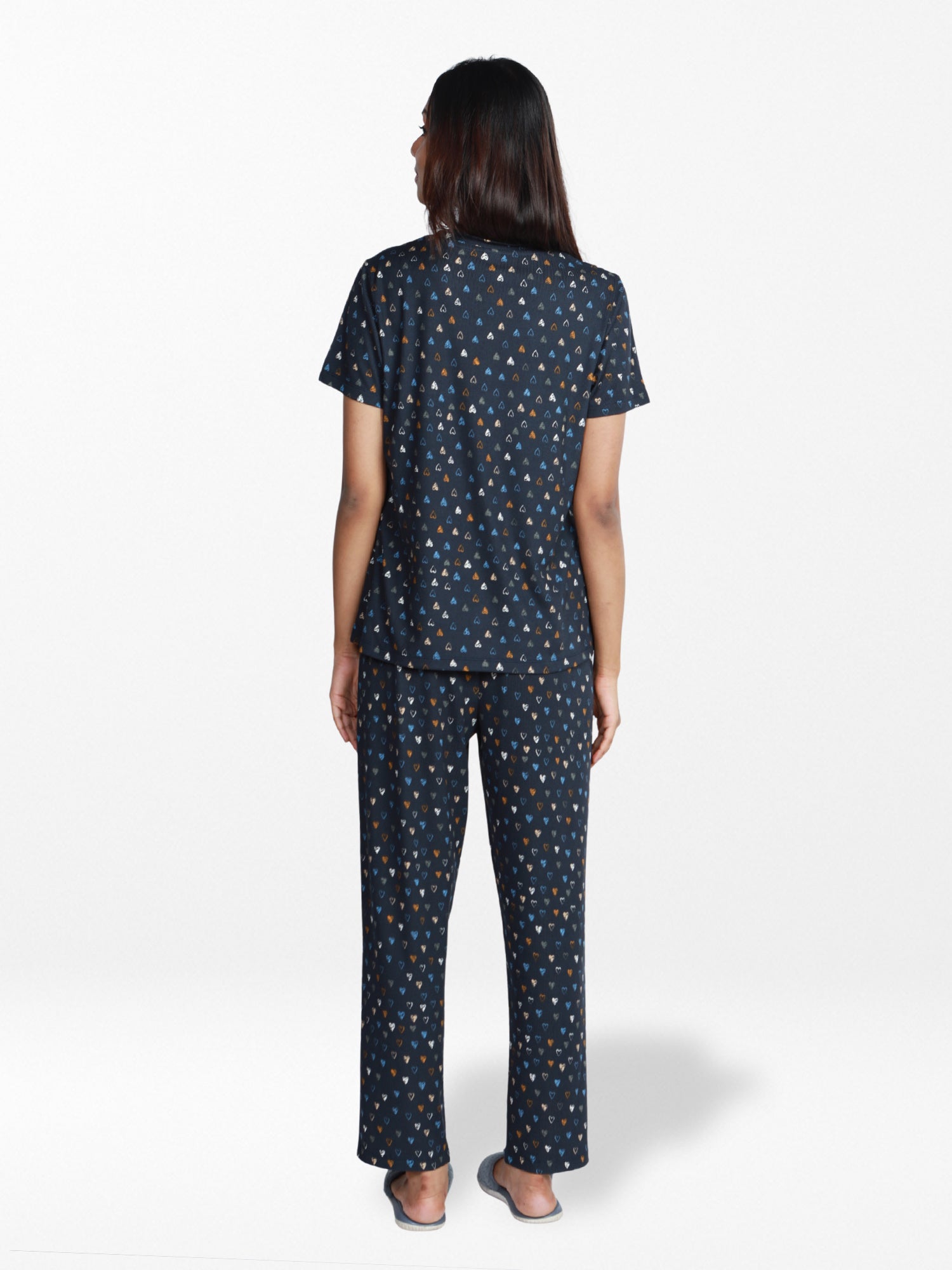 Woman wearing a navy blue pajama set with a subtle pattern on a white background