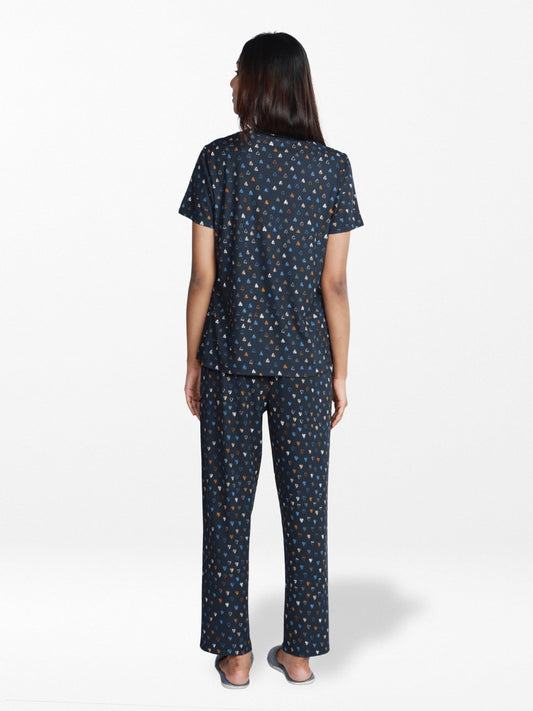 Woman wearing a navy blue pajama set with a subtle pattern on a white background
